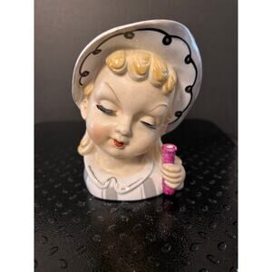 vintage ceramic head vase features a young girl with blonde hair and lace bonnet